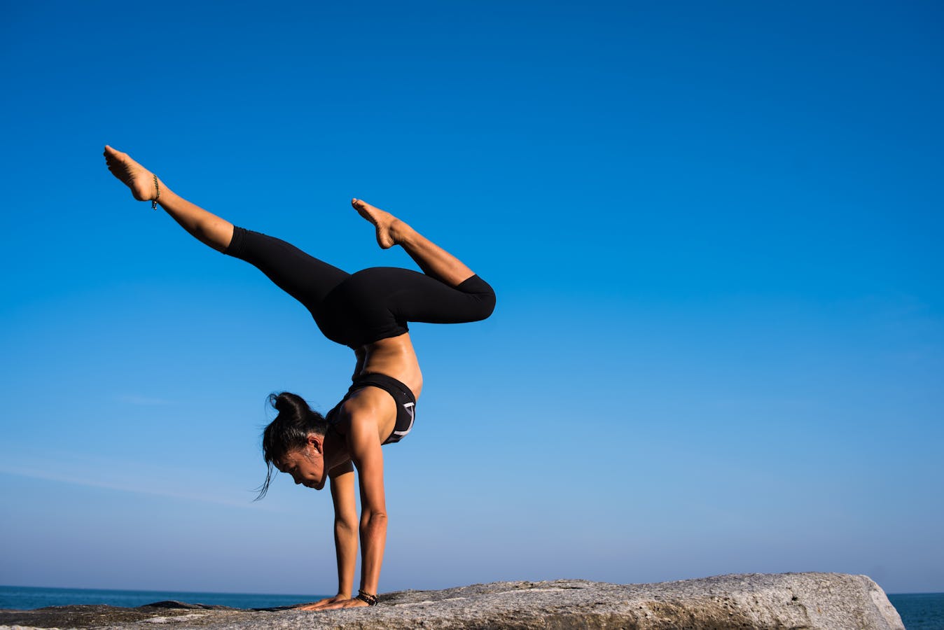 Person practicing yoga on the beach at sunrise